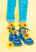 Blue boots adorned with sunflowers against a yellow background.